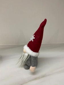Side view of a Christmas gnome doll featuring a red snowflake hat and long grey beard