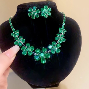 Vue détaillée du parure de bijoux fleur émeraude avec collier et boucles d'oreilles