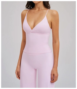 Détail du dos d'une brassière de yoga rose avec fines bretelles croisées et tissu doux