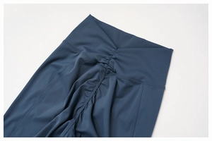 Détail de la taille haute en V et de la couture froncée sur le legging de yoga gris bleu