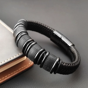 Handwoven multi-layer black leather bracelet with textured steel cylinders and magnetic clasp