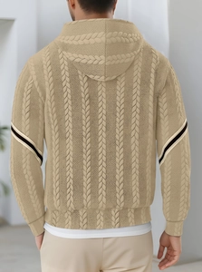 Detail of knitted men's hoodie showing thick cable knit texture and striped sleeve