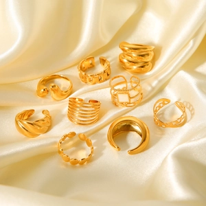 Collection of nine gold geometric open rings displayed on elegant silk background