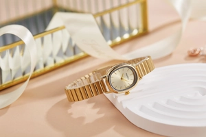 Dettaglio macro dell'elegante orologio al quarzo ovale dorato con cinturino in metallo