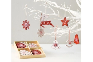 Close-up of red and white wooden Christmas ornaments with snowflake patterns in a wooden box