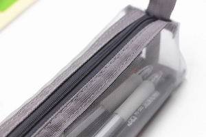 Close-up of grey mesh pencil case featuring a durable metal zipper and fine mesh texture