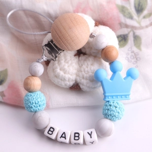 Detail of baby pacifier chain with blue crown, silicone beads and beech wood clip