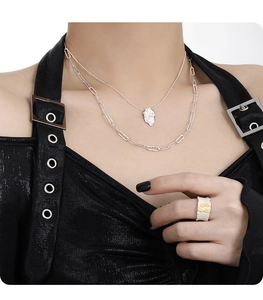 Detail of silver S925 necklace and irregular lava texture ring on a female model