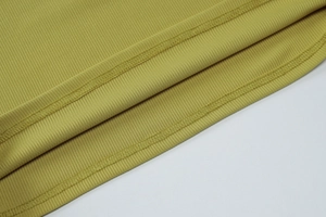 Détail du tissu en maille côtelée vert olive et coutures d'ourlet à double aiguille