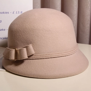 Détail du chapeau cloche en laine vieux rose avec nœud et boucle en métal doré