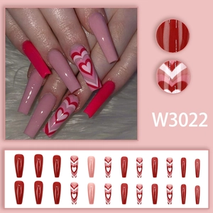 Detail view of long coffin press-on nails in red and pink ombre heart gradient style