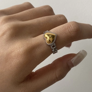 Two-tone stainless steel ring with golden heart on silver chain band worn on hand