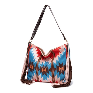 Close-up of bohemian shoulder bag with geometric patterns and long side tassels