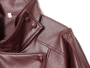 Macro detail of wine red faux leather texture with matching buttons on a biker jacket