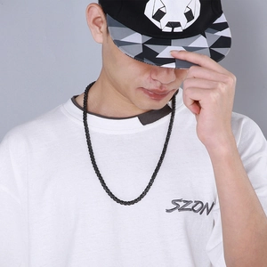 Close-up of a retro black stainless steel curb chain necklace on a male model in streetwear