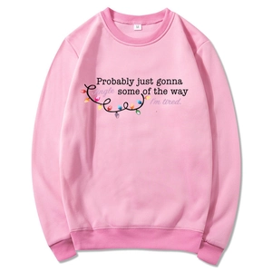Detail of pink crewneck sweatshirt featuring M size tag and festive jingle text print