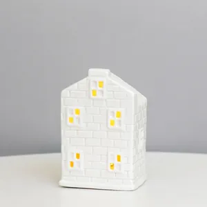 Detail of white ceramic LED house lamp with warm light and hollow windows 7.5x6.5x10.5cm