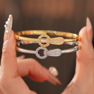 Detail of interlocking gold and silver bangles with micro-pave cubic zirconia settings
