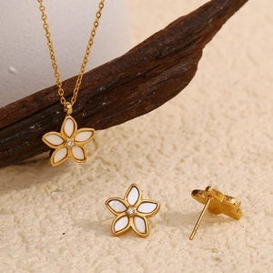 Detailed view of 18K gold plated shell flower necklace and earrings set with small diamond