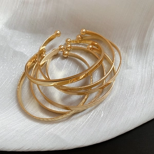 Detail view of gold-plated bangle set with LOVE engraving and hammered textures