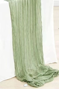 Detail of green cheesecloth table runner with crinkle texture for wedding decor