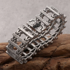 Detail of vintage steel link bracelet with wolf head clasp on rustic wood texture
