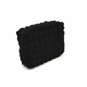 Close-up of black bubble fabric texture and zipper detail on portable cosmetic bag