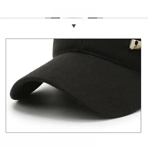 Detail of curved brim on black winter baseball cap with metal logo and thick fabric