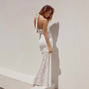 Detail of white lace halter dress showing intricate crochet patterns and lace-up neck design