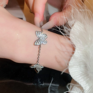 Close-up of a silver butterfly bracelet with clear zircons worn on a model's wrist