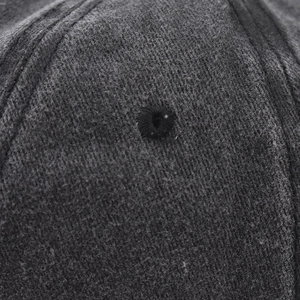 Macro shot of embroidered ventilation eyelet and stitching on a charcoal baseball cap