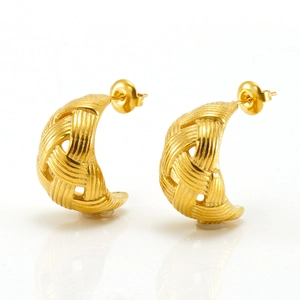 Golden woven crescent hoop earrings with brushed metal texture on white background