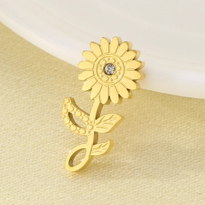 Macro shot of gold sunflower pendant with clear crystal on beige fabric background