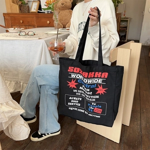 Close-up of black canvas tote bag with vintage American style red and blue graphic print