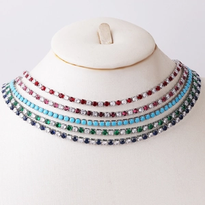 Multiple colorful 3.0 zircon tennis necklaces displayed on a white mannequin stand