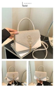 Detail of champagne gold glitter fabric bag with SS metal logo and elegant tassel
