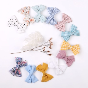 Flat lay of colorful fabric bow hair clips in various patterns and pastel colors