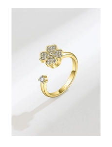 Macro shot of gold-tone spinning clover ring with crystal zircon stones and polished finish