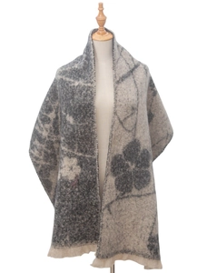 Detail of wool blend floral jacquard shawl with tassel fringe on a mannequin model