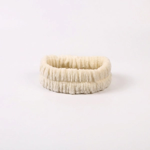 Detail of soft cream coral fleece headband with high elastic pleated texture for skincare
