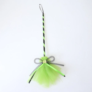 Detail of Halloween witch broom with neon green mesh and sequin ribbon bow accessory