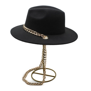 Classic black felt fedora hat featuring a bold gold link chain on a metal display stand