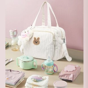 Quilted white tote bag with bear embroidery shown with baby supplies for storage detail