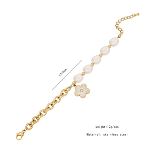 Detail of stainless steel gold chain bracelet with pearl and rhinestone flower charm