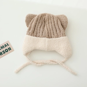Dettaglio cappello invernale in maglia per bimbi con orecchie e laccetti intrecciati