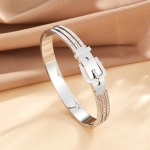 Detail of silver belt buckle bracelet with sparkling rhinestone inlay on satin