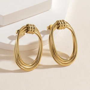 Minimalist 14K gold plated stainless steel layered oval earrings on a white stone base