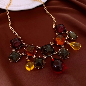 Macro detail of vintage square resin necklace with amber and green stone charms