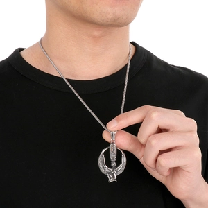 Detail of silver angel wing pendant on a man's neck with Egyptian goddess carving