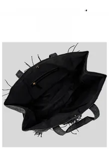 Detail view of black woven tote bag interior with zipper pocket and magnetic closure